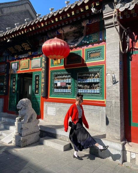 Lily Collins kicking her leg in front of a japanese temple