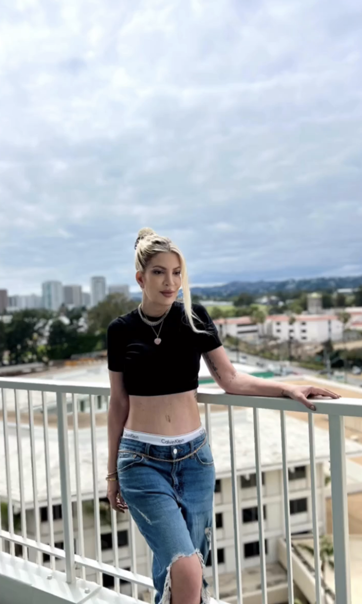 Tori Spelling posing on a balcony